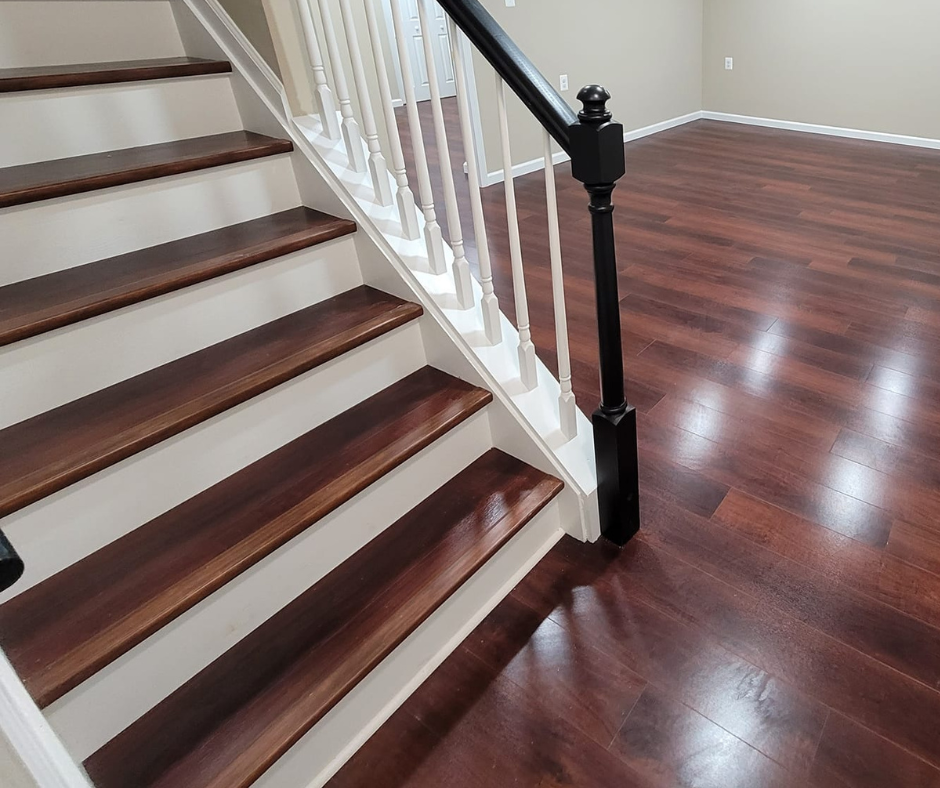 a closeup of a beautiful staircase featuring cherry wood flooring and an elegant turned wood banister