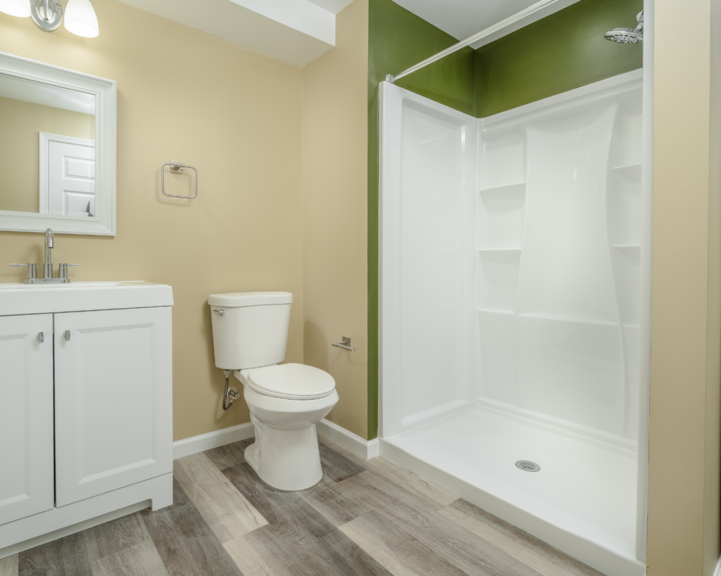 a remodeled bathroom with vanity, toilet, and shower enclosure