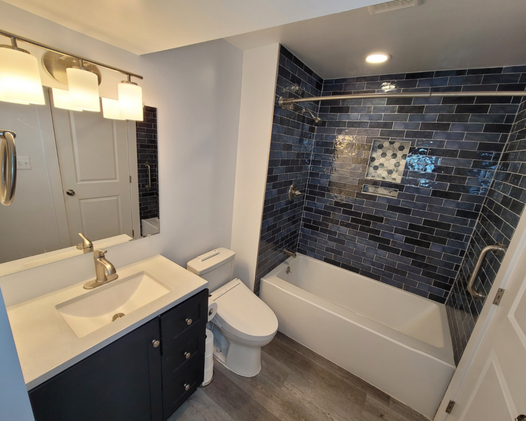 a remodeled bathroom with vanity, toilet, and tub with shower in frederick md