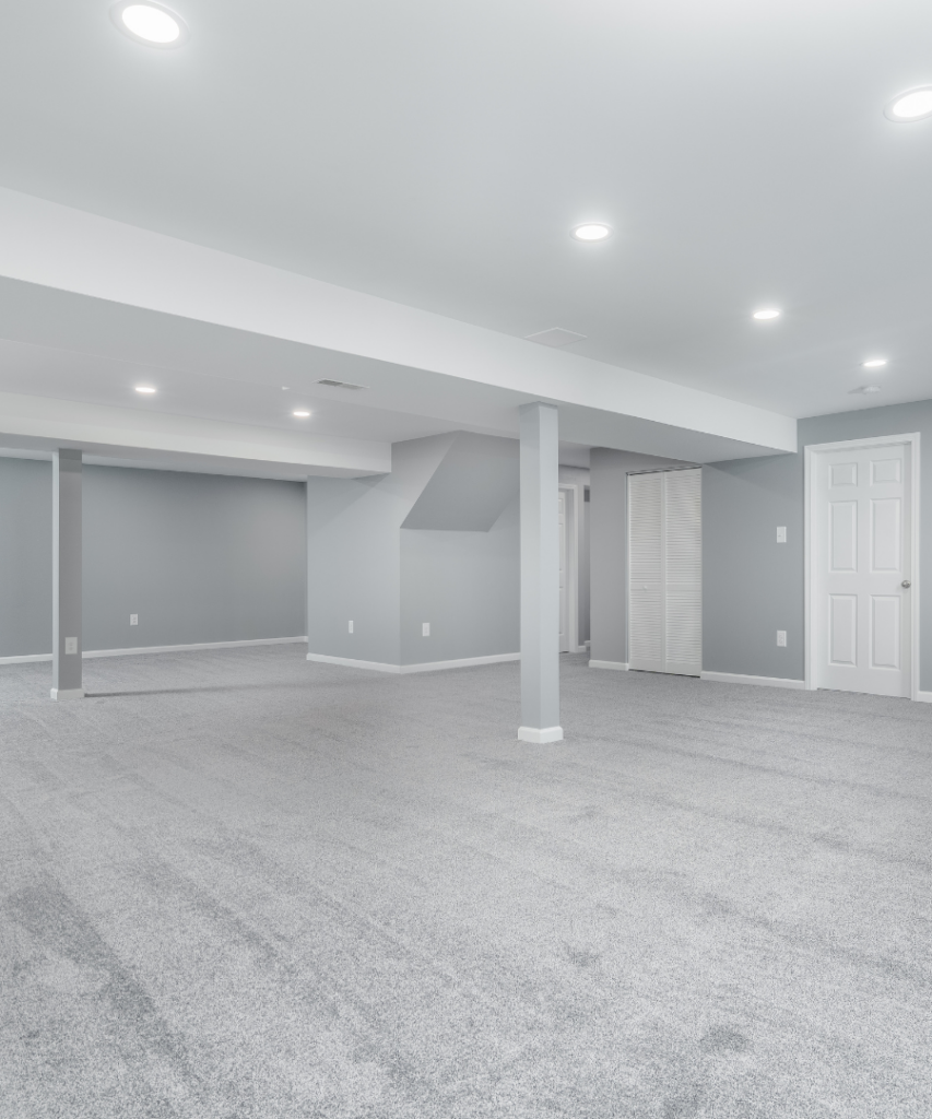 a recent basement remodeling project featuring neutral gray walls and gray wall to wall carpeting.