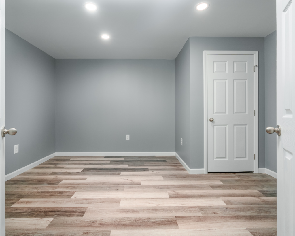 beautiful wide-paneled laminate flooring in a basement remodel by the homeowners helper