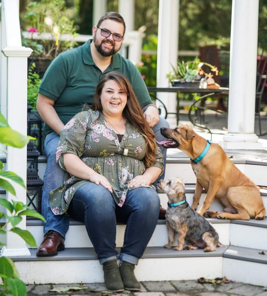 Cody and Stephanie ward with their dogs, sitting on some steps of a deck in frederick md